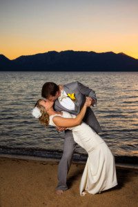 bride and groom kissing, dip on beach, sunset – South Lake Tahoe lakefront beach wedding nina photographer