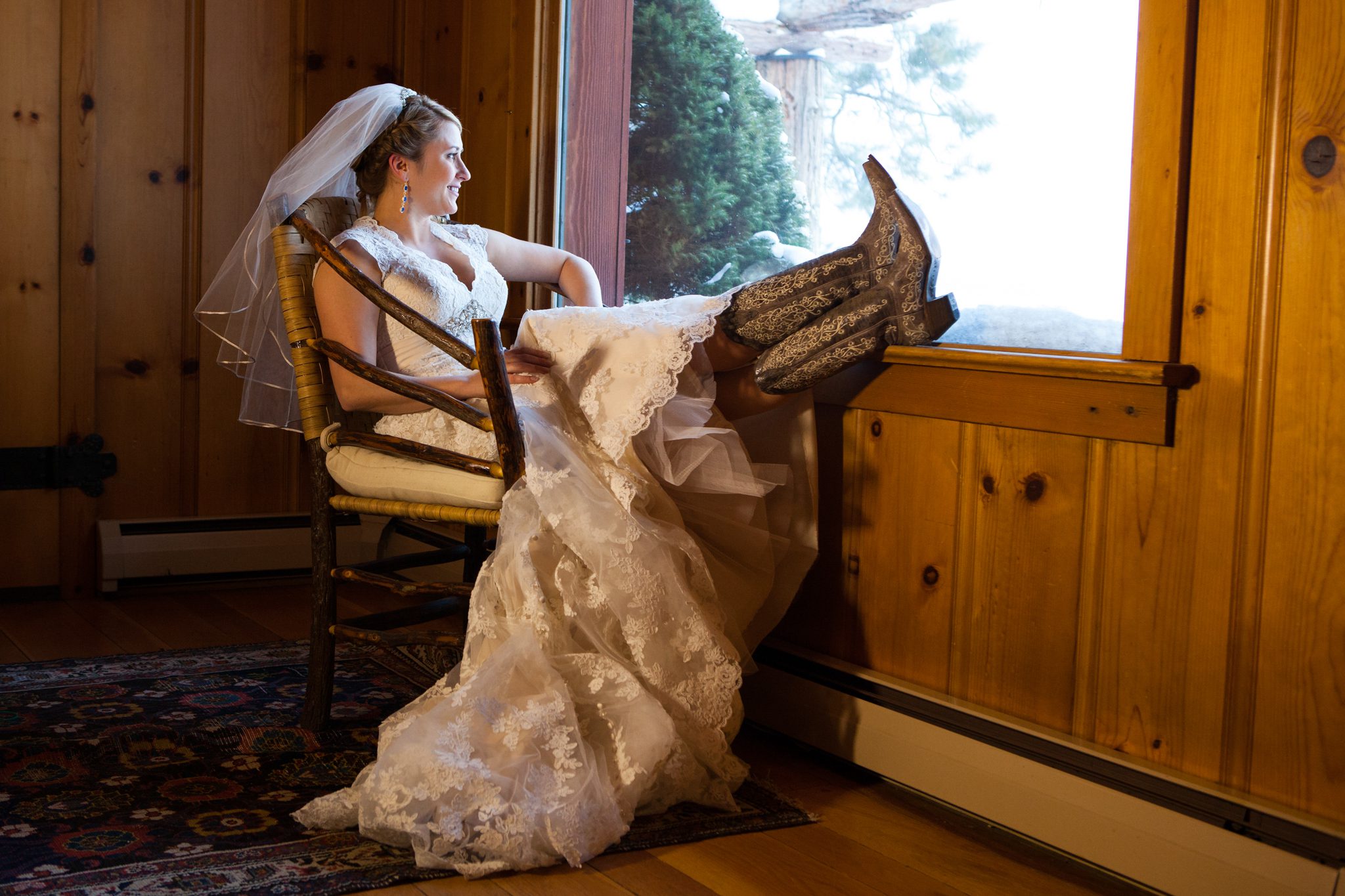 bride portrait sitting by window, cowboy boots, dress