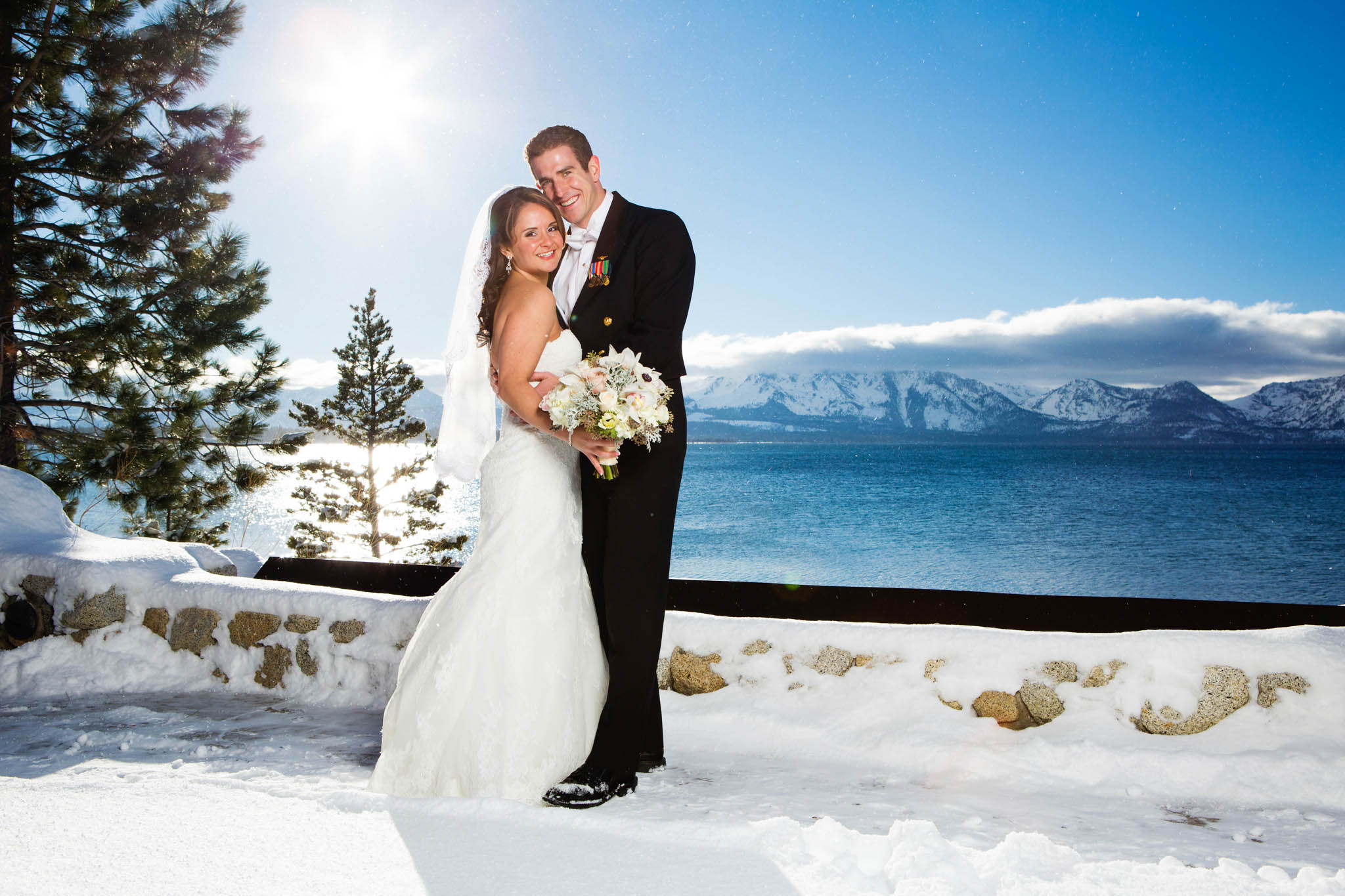 bride and groom looking at camera, lake view, snow, white bouquet
