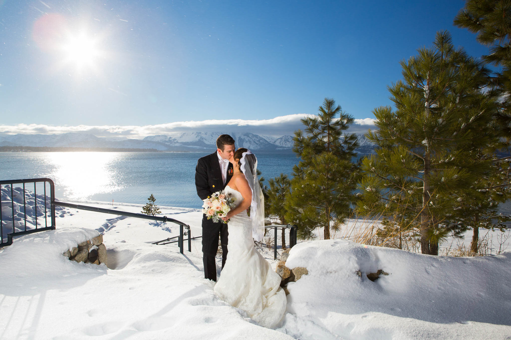 bride and groom portrait, lake view, snow, white bouquet, sun flare, uniform