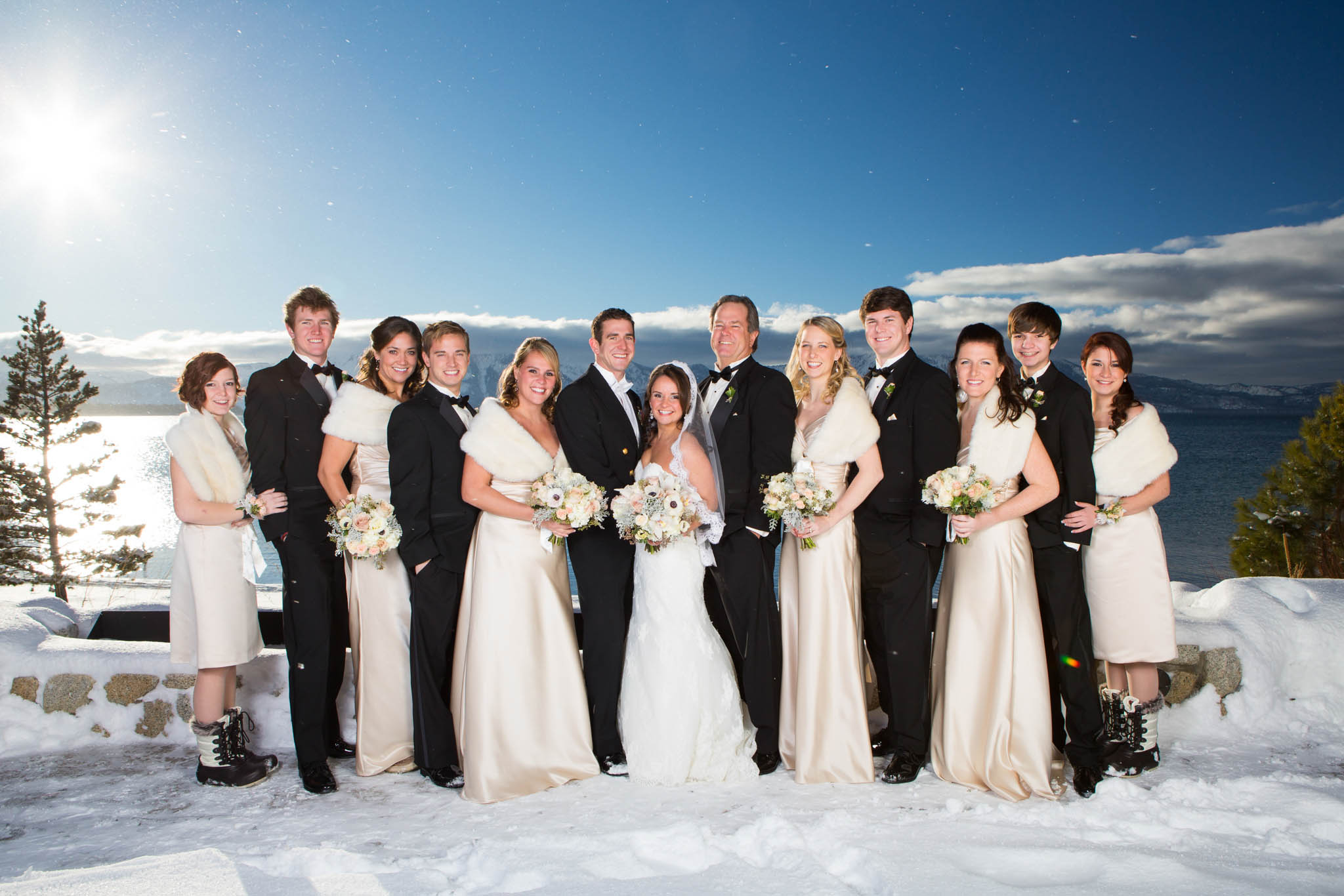 bridal party portrait, champagne bridesmaids' dresses, white bouquets, snow, winter, lake, blue