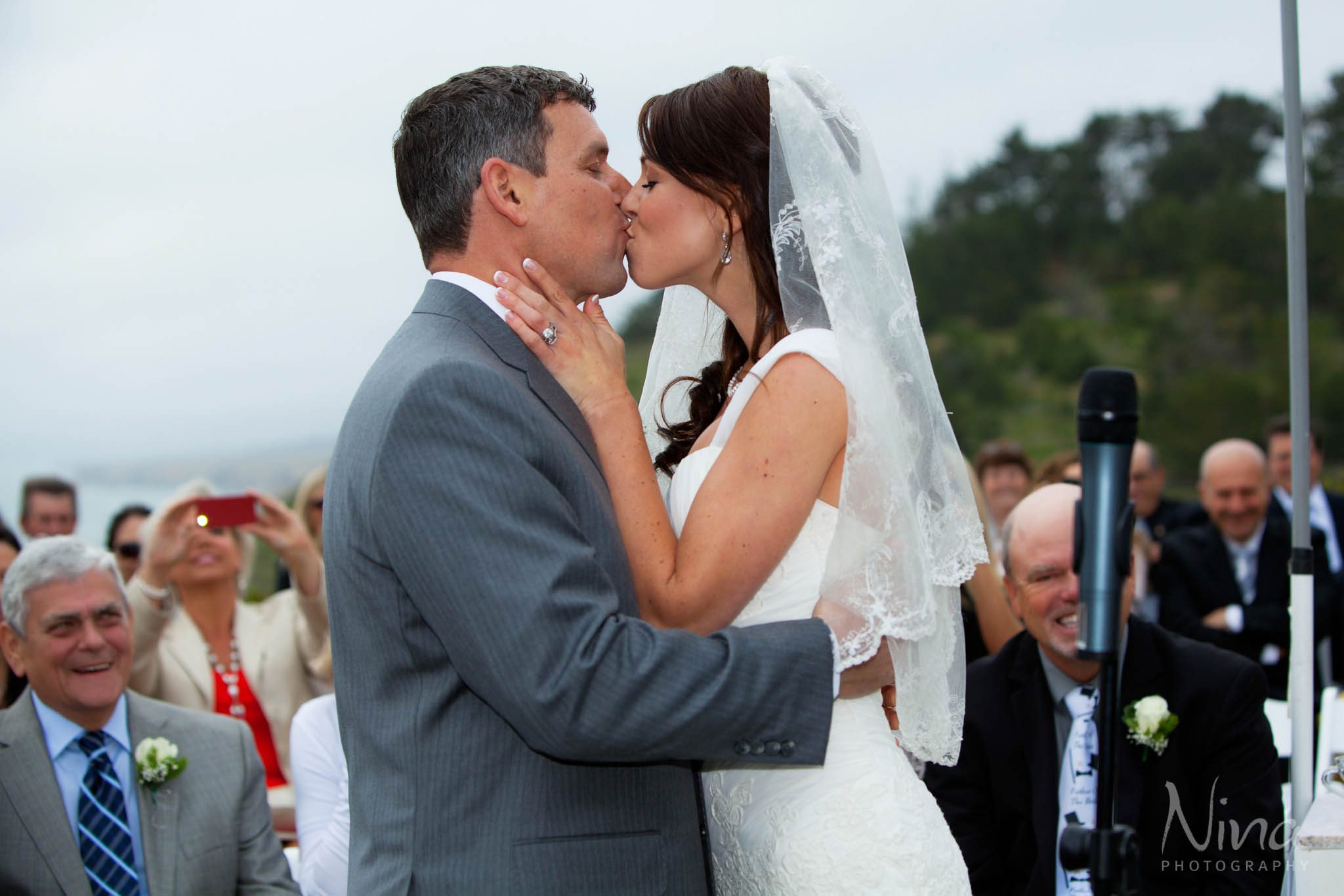 bride groom kissing wedding ceremony photographer
