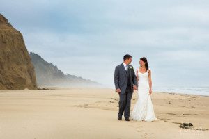 bride groom walking on beach ocean portrait photography 2