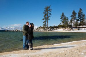 couple portrait on beach, snow, sand, blue green water, mountains, trees
