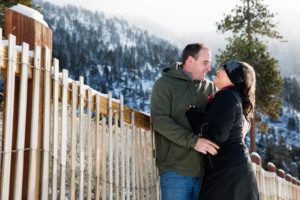 couple portrait by fence, beach, trees, mountains